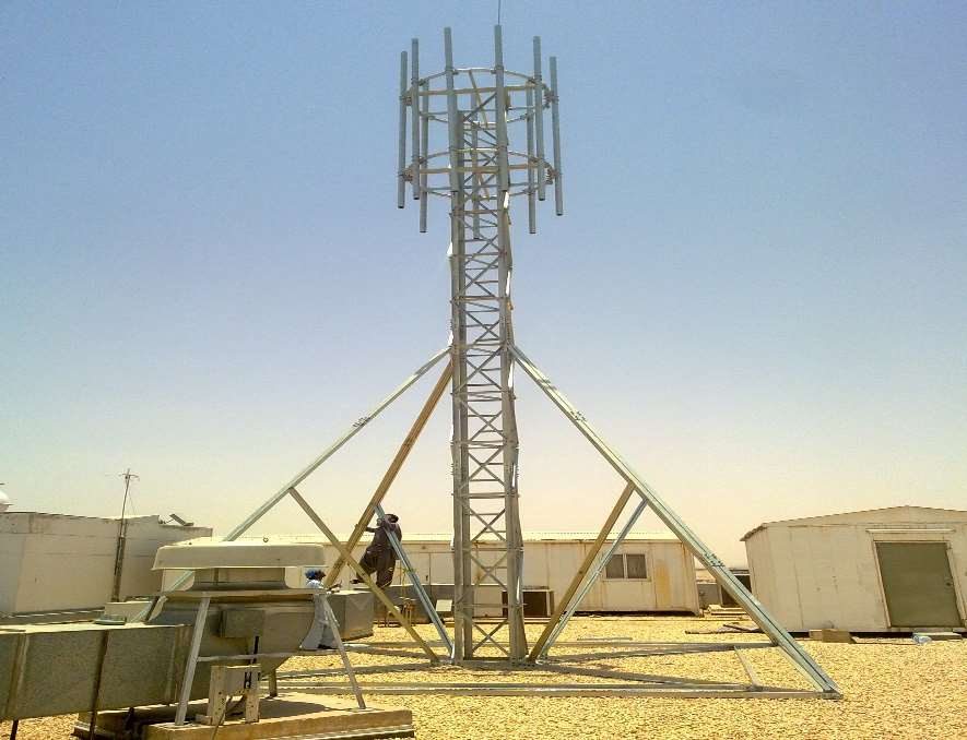 Technician installing a self-supporting telecom tower on a rooftop