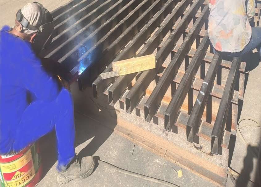 AYZAN welder fabricating a steel grating panel