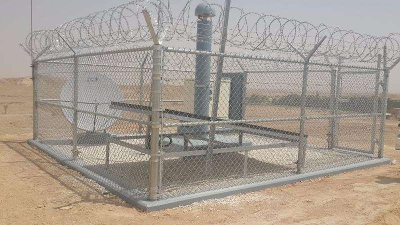Chain-link enclosure with barbed wire around utility equipment